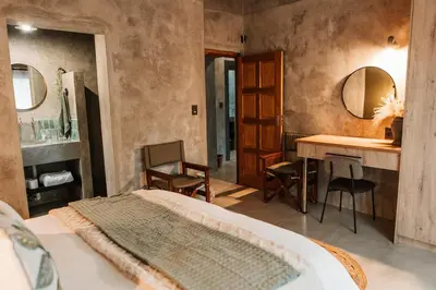 a bedroom with a bed and a vanity and a sink at Chawal Stays Ribbok in Marloth Park