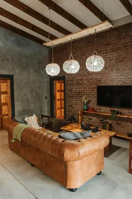 a living room with a large brown leather couch at Chawal Stays Ribbok in Marloth Park