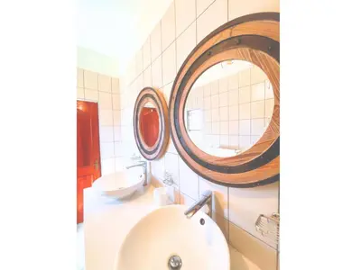 a bathroom with a sink and two mirrors on the wall at Mushavi Manor in Sybrandskraal