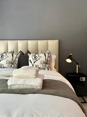 a bedroom with a bed with pillows and a lamp at Pass-through Apartments in Pretoria