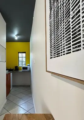 a hallway of a kitchen with a painting on the wall at Pass-through Apartments in Pretoria