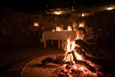 a fire pit with a table in the background at Ekuthuleni Lodge in Welgevonden Game Reserve