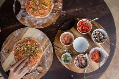 a table with two pizzas and other dishes on it at Ekuthuleni Lodge in Welgevonden Game Reserve