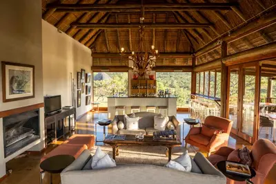a living room with a couch and a fireplace at Ekuthuleni Lodge in Welgevonden Game Reserve