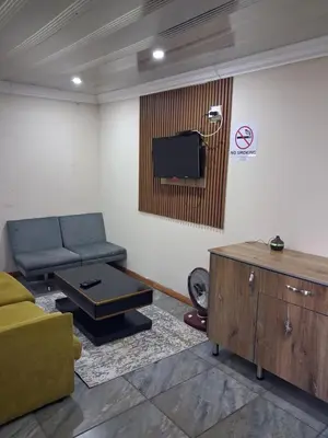 a living room with a couch and a flat screen tv at Eazistay Motel - Letlhabile in Brits