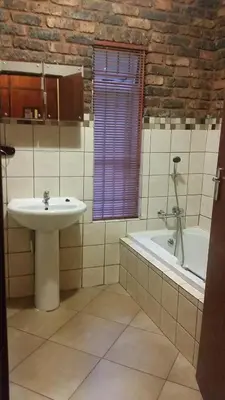 a bathroom with a sink and a tub and a window at Private Apartments & Biz Stays Pretoria in Pretoria