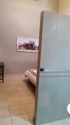 a room with a glass door with a picture of elephants at Private Apartments & Biz Stays Pretoria in Pretoria