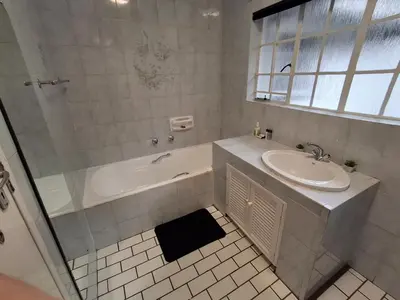 a bathroom with a tub and a sink and a shower at 118 Bayley Street in Benoni