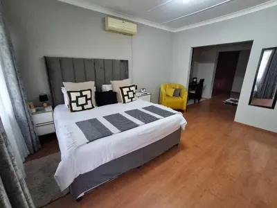 a bedroom with a large bed and a wooden floor at 118 Bayley Street in Benoni
