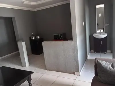 a living room with a sink and a sink at Matswabolle Guest Lodge in Gowe