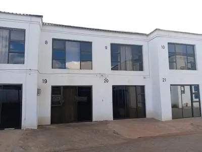 a white building with doors and numbers on it at Matswabolle Guest Lodge in Gowe