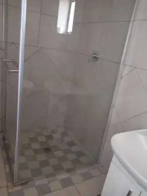 a shower with a glass door in a bathroom at Matswabolle Guest Lodge in Gowe