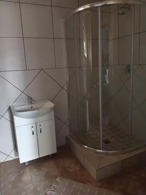 a bathroom with a shower with a toilet and a sink at Matswabolle Guest Lodge in Gowe