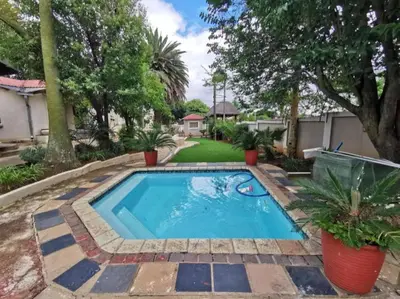 a swimming pool in a yard with trees at Catwalk Lodge in Pretoria
