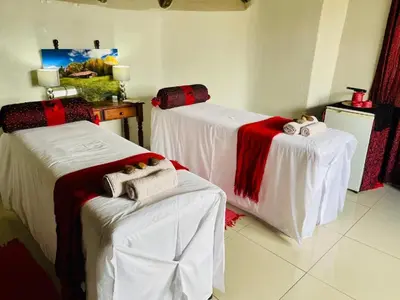 a room with two beds with red and white blankets at Catwalk Lodge in Pretoria