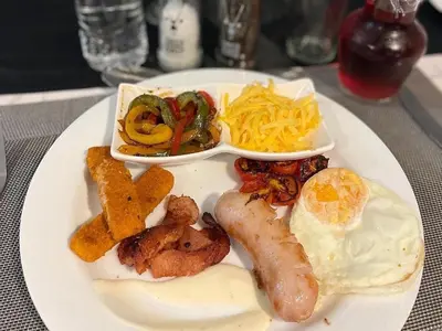a plate of breakfast food with eggs sausage and vegetables at Catwalk Lodge in Pretoria
