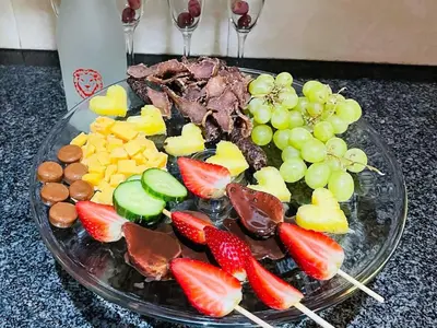 a plate of food with fruit on a table at Catwalk Lodge in Pretoria