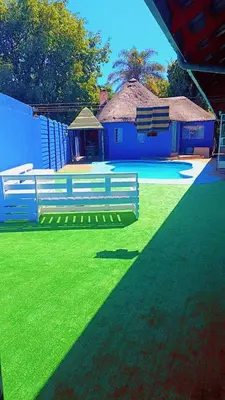 a blue bench on a field of green grass at BATO Accommodation in Kempton Park