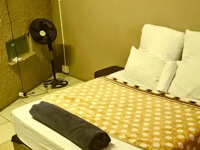 a bedroom with a bed with a pillow and a fan at BATO Accommodation in Kempton Park