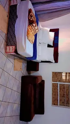 a bedroom with a bed with white sheets and pillows at BATO Accommodation in Kempton Park