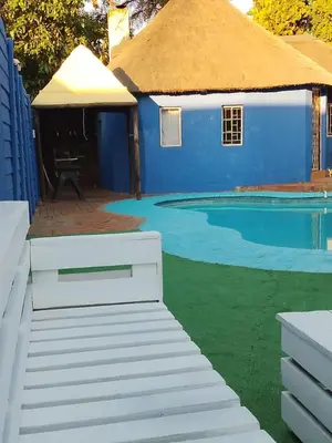 a small blue building with a swimming pool at BATO Accommodation in Kempton Park
