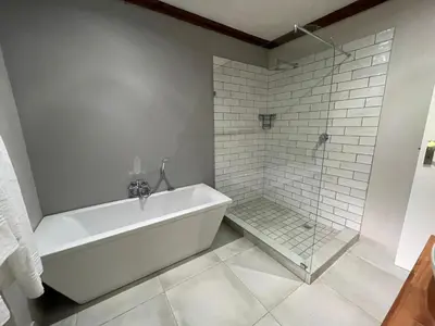 a white bathroom with a tub and a shower at Riecor Guest Farm in Thabazimbi