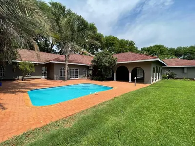 a house with a swimming pool in the yard at Riecor Guest Farm in Thabazimbi