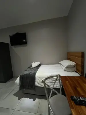 a bedroom with a bed with a tv on the wall at Riecor Guest Farm in Thabazimbi