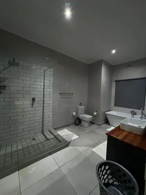 a bathroom with a shower and a sink and a toilet at Riecor Guest Farm in Thabazimbi