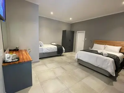 a bedroom with two beds and a counter in it at Riecor Guest Farm in Thabazimbi