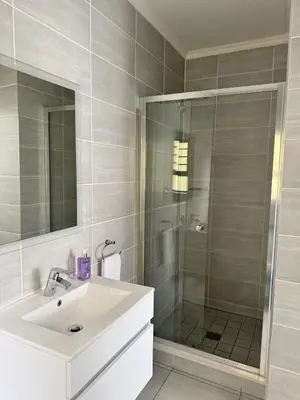 a bathroom with a white sink and a shower at Comfy 2-Bedroom at Kikuyu Estate in Johannesburg