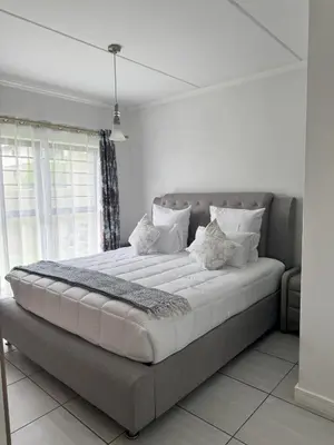 a large bed in a room with a window at Comfy 2-Bedroom at Kikuyu Estate in Johannesburg