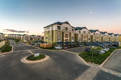 a large building with a parking lot in front of it at Comfy 2-Bedroom at Kikuyu Estate in Johannesburg