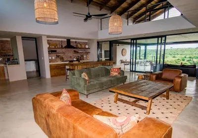 a living room with couches and a table at Horizons River Lodge Mjejane in Hectorspruit