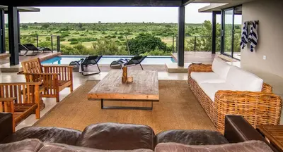 a living room with a couch and a table at Horizons River Lodge Mjejane in Hectorspruit