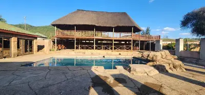 a large building with a thatch roof and a swimming pool at Musanda Lifestyle Centre in Makonde
