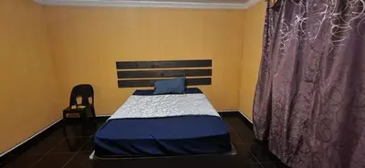 a small bedroom with a bed and a chair at Musanda Lifestyle Centre in Makonde