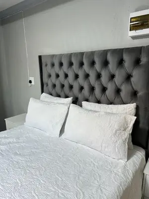 a bedroom with a large bed with white sheets and pillows at Maduwa Guest House in Pretoria