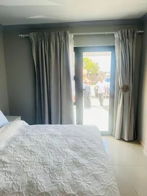 a bedroom with a bed and a sliding glass door at Maduwa Guest House in Pretoria