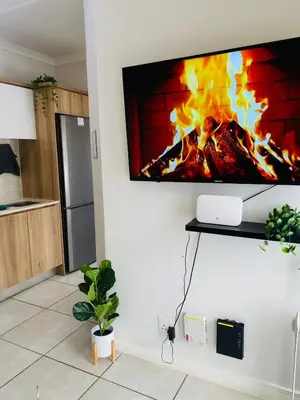 a tv hanging on a wall with a fireplace at Kayalako at theBlyde 1 in Pretoria