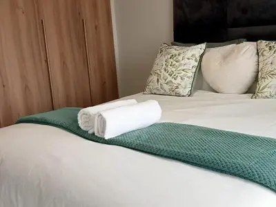 a bed with two rolled towels on top of it at Kayalako at theBlyde 1 in Pretoria