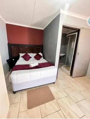 a bedroom with a white bed with red walls at MD Guesthouse Debruin park in Ermelo
