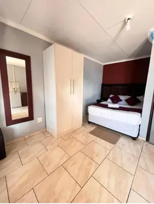 a bedroom with a bed and a mirror at MD Guesthouse Debruin park in Ermelo
