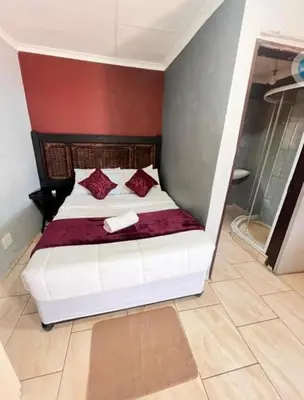 a bedroom with a white bed with red walls at MD Guesthouse Debruin park in Ermelo