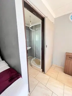a bedroom with a glass door leading to a shower at MD Guesthouse Debruin park in Ermelo