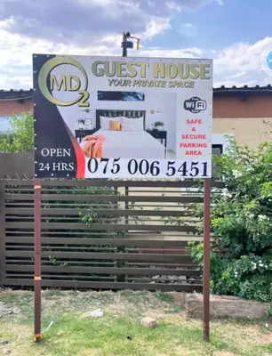 a guest house sign in front of a guest house at MD Guesthouse Debruin park in Ermelo