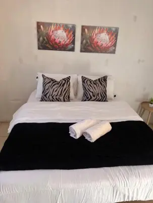 a large white bed with two towels on it at Begin Guesthouse in Ermelo