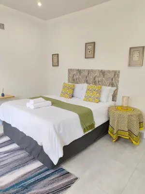 a bedroom with a large bed and a table at Masingita Guest House in Graskop