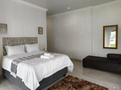 a bedroom with a large bed and a couch at Masingita Guest House in Graskop