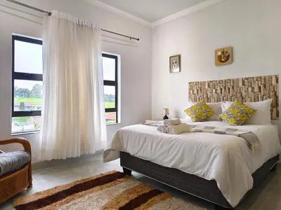 a bedroom with a large bed and a window at Masingita Guest House in Graskop